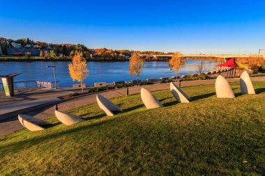 Bir sıra heykel bir nehrin yanındaki çimenli bir yamaca yerleştirilir. Heykeller çeşitli şekil ve boyutlardadır ve hareket ve akış hissi yaratacak şekilde düzenlenmişlerdir.