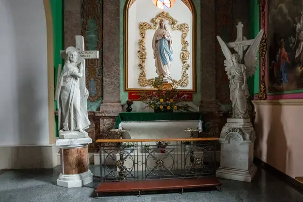 Meryem 'in heykeli ve bir meleğin olduğu bir kilise. Mary 'nin heykeli bir haç tutuyor