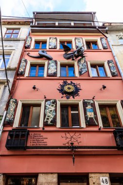 A building with a clock on the front has a sign that says 