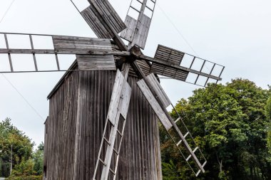 Ahşap bir yapısı ve büyük ahşap kulesi olan bir yel değirmeni. Yel değirmeni eski ve kırsal bir görünüme sahip. Etrafı ağaçlarla çevrili. Huzurlu ve huzurlu bir atmosfer yaratıyorlar.
