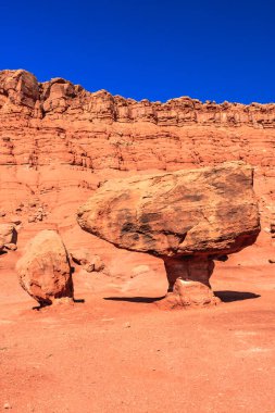 Büyük bir kaya, daha küçük kayalarla çevrili çölde oturur. Sahne ıssız ve çorak, yaşam belirtisi yok.