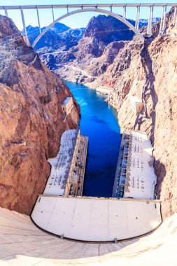 Bir dağ sırasının üstündeki gökyüzüne büyük bir su kütlesi yansıtılır. Su sakin ve berrak, gökyüzü parlak ve mavi. Huzurlu ve huzurlu bir sahne.