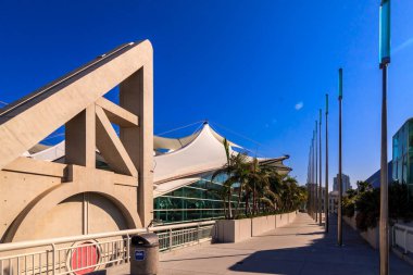 Beyaz çatılı ve arkasında mavi gökyüzü olan büyük bir bina. Binanın üçgen şekli var.