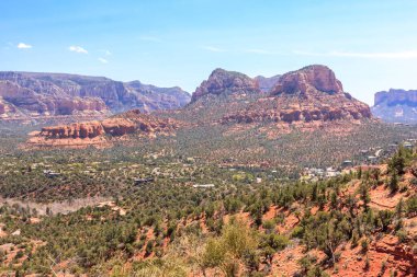 Uzakta küçük bir kasabası olan güzel bir dağ sırası. Gökyüzü açık ve güneş parlıyor.