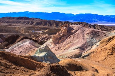 Kayalık bir yamacı ve uzakta bir arabası olan bir dağ sırası. Huzurlu ve huzurlu bir sahne.