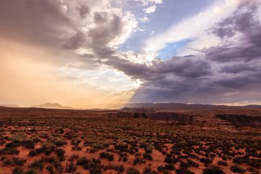 Bulutların arasından parlayan güneşli bulutlu bir gökyüzü. Gökyüzü turuncu ve güneş gökyüzünün ortasında.