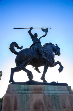 Elinde kılıçla ata binen bir adamın heykeli. Heykel bronzdan yapılmıştır ve bir parkta bulunmaktadır.
