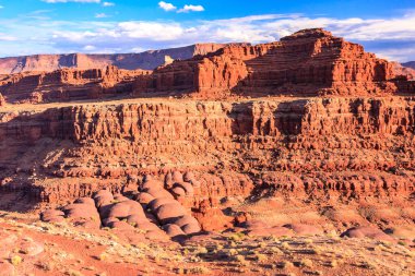Arkasında dağ olan bir çöl manzarası. Dağ kayalarla kaplı ve çöl kuru ve çorak.