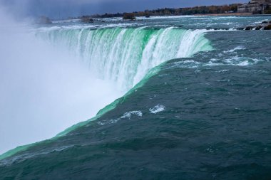Yeşil suyu olan bir şelale. Su bir uçurumdan aşağı akıyor. Su çok berrak ve su çok yeşil.