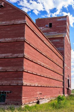 Çatısı eğimli kırmızı tuğlalı bir bina. Bina eski ve kırsal bir görünüme sahip.