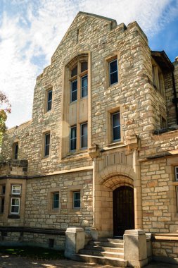 Büyük kemerli ve geniş pencereli büyük bir taş bina. Bina eski ve bir sürü penceresi var.