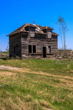Üzerinde mavi bir gökyüzü olan bir tarlada küçük, eski bir ev oturuyor. Ev bakımsız durumda, bir sürü odun eksik ve bir kaç pencere de tahta kaplı. Sahne terk edilme ve ihmalkarlıktır.