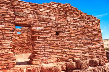 Ortasında pencere olan kırmızı tuğla bir duvar. Duvar çok eski ve bir sürü çatlağı var.