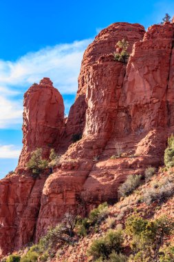 Gökyüzü manzaralı kayalık bir dağ. Kayalar kırmızı ve gökyüzü mavi.