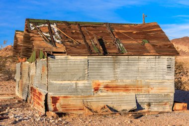 Yeşil çatılı paslı, eski bir bina. Çatıda 