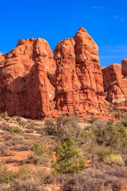 Açık mavi gökyüzü olan kayalık bir dağ sırası. Dağlar yüksek ve kayalık, gökyüzü parlak ve berrak. Huzurlu ve huzurlu bir manzara. Dağlar ihtişam hissi veriyor.