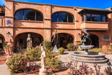 Önünde çeşme olan bir bina. Çeşmenin üzerinde bir kadın heykeli var.