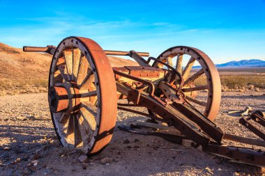 Çölde eski, paslı bir el arabası oturuyor. Sahne ıssız ve çorak, yaşam belirtisi yok. El arabası sert ve affetmez çevrenin bir sembolüdür.