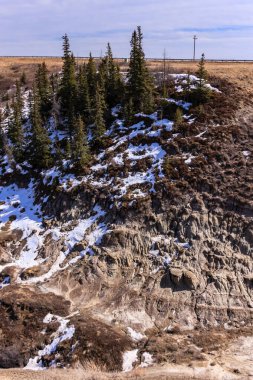Karla ve ağaçlarla kaplı bir dağ. Ağaçlar çıplak ve kar derin.