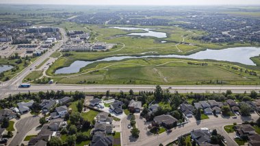 An aerial drone photo of the Lakeridge neighborhood in Saskatoon, Saskatchewan, showcasing residential homes, parks, tree-lined streets, and community amenities in this family-friendly suburban area. clipart