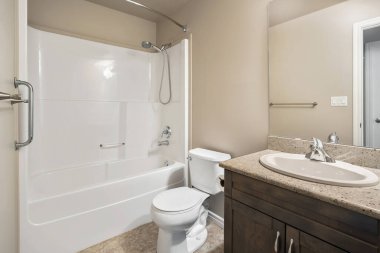 Beyaz tuvaleti ve lavabosu olan bir banyo. Banyo temiz ve bakımlı.