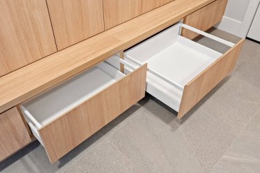 Altında iki çekmece olan ahşap bir bank. Çekmeceler boş ve tezgah fayanslarla döşenmiş. Sahne basit ve düzenlidir.