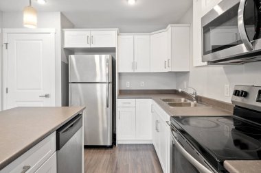 Temiz ve iyi organize edilmiş bir mutfak paslanmaz çelik buzdolabı, mikrodalga fırın ve fırın. Tezgah granitten yapılmış ve lavabo paslanmaz çelikten.