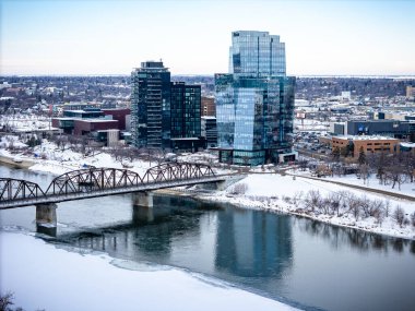 Büyük camdan bir binası ve nehir üzerinde köprüsü olan bir şehir. Köprü metalden yapılmıştır ve karla kaplıdır. Şehir sessiz ve huzurlu. Kar zemini ve binaları kaplıyor.