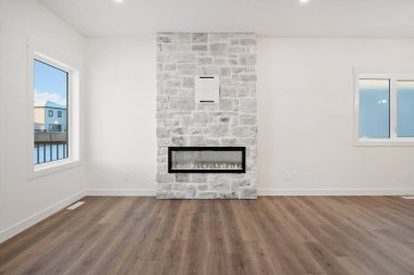 Büyük bir şömine büyük, boş bir oturma odasının odak noktasıdır. Oda büyük ve boş, sol tarafında büyük bir pencere ve sağ tarafında daha küçük bir pencere var.