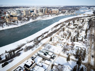 Altında nehir akan karlı bir şehir. Nehir dondu ve şehir karla kaplandı.