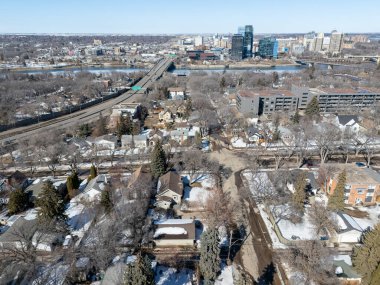 Şehir manzarası ve içinden bir nehir geçiyor. Evlerin hepsi dizilmiş ve bir sürü ağaç var.