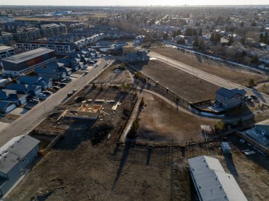 Evleri ve birkaç arabası olan bir yerleşim yeri. Evlerin çoğu beyaz ve cadde ağaçlarla kaplı.