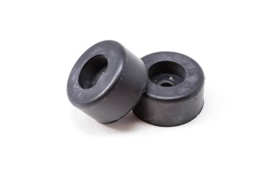 Beyaz arka plana iki siyah lastik tıpası yerleştiriliyor. Engelleyicilerin boyutları ve şekilleri aynı.