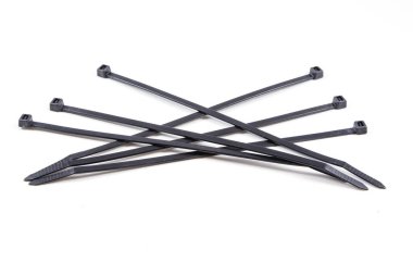 Beyaz arka planda bir sürü siyah kablo var. Kablolar aynı uzunlukta ve sırayla dizilmiş.