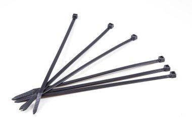 Beyaz arka planda bir sürü siyah kablo var. Kablolar aynı uzunlukta ve sırayla dizilmiş.