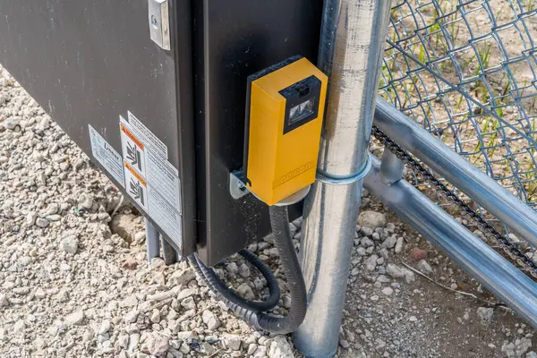 Üzerinde sarı bir kutu olan kara kutu. Kutu metal bir direğe bağlı.