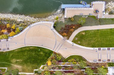 Yolu ve bankı olan bir park yeri. Yol tuğladan yapılmıştır ve bank suya yakındır.