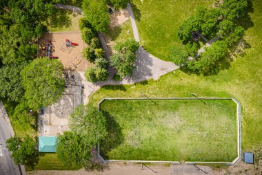 Çocuk parkı ve tarlası olan bir park yeri. Oyun parkında salıncak ve kaydırak var. Saha yeşil ve çitleri var.