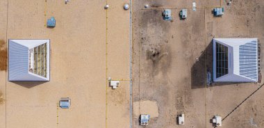 Üzerinde iki küçük bina olan çatı. Binalar kir ve molozla kaplı ve çatı da siyah muşambalarla kaplı. Sahne ihmalkarlık ve çürümedir.