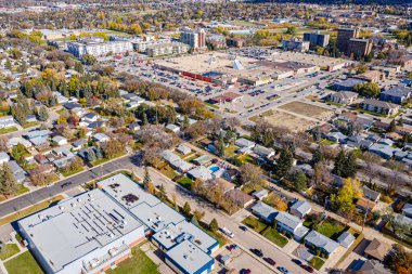 Arka planda büyük bir bina olan şehir caddesi manzarası. Sokaklar arabalar ve kamyonlarla dolu.