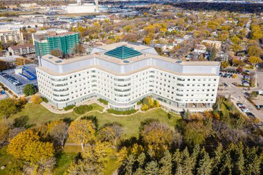 Yeşil çatısı ve tepesinde kubbesi olan büyük beyaz bir bina. Bina ağaçlar ve otlarla çevrili.