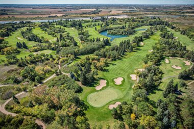 Yeşil manzaralı ve göletli golf sahası. Golf sahası iyi korunuyor ve huzurlu bir atmosferi var.