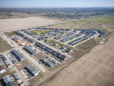 Birçok evi ve birkaç arabası olan bir yerleşim yeri. Evlerin çoğu beyaz ve arabalar garaj yolunda park halinde.