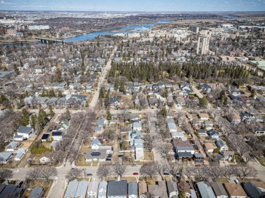 Şehir manzarası yukarıdan, içinden bir nehir akıyor. Evlerin çoğu beyaz ve caddede birkaç araba var.