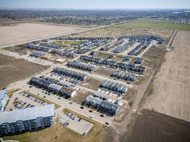 Bir sürü evi ve birkaç arabası olan bir yerleşim yeri. Evler çoğunlukla beyaz ve arabalar da çoğunlukla beyaz.