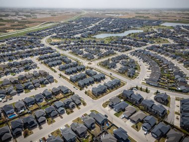 Bir sürü evi ve birkaç arabası olan bir yerleşim yeri manzarası. Evler çoğunlukla siyah ve cadde ağaçlarla kaplı.