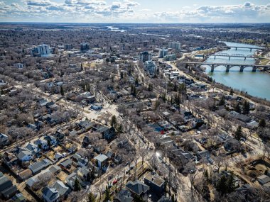 Şehir manzarası ve içinden bir nehir geçiyor. Evlerin çoğu beyaz ve bir sürü ağaç var.