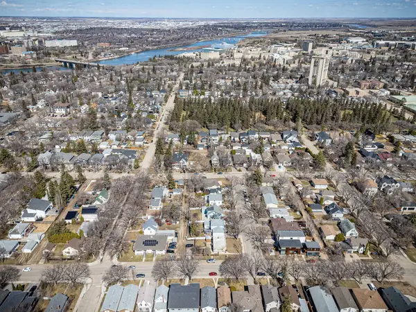 Şehir manzarası yukarıdan, içinden bir nehir akıyor. Evlerin çoğu beyaz ve caddede birkaç araba var.