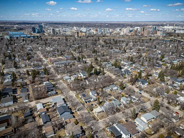 Şehir manzarası yukarıdan birçok ev ve ağaçla dolu. Evlerin çoğu beyaz ve ağaçlar çıplak.