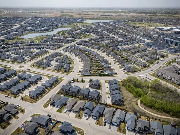 Arka planda evleri ve gölü olan bir banliyö mahallesi. Evlerin çoğu beyaz ve caddeye park edilmiş bir sürü araba var.